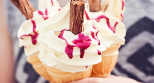 Girl-holding-three-ice-cream-cones-with-raspberry-sauce